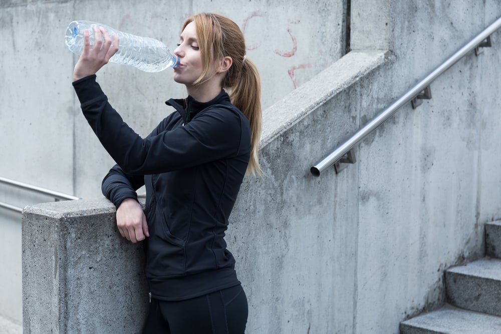 Young woman runner having break during exercises