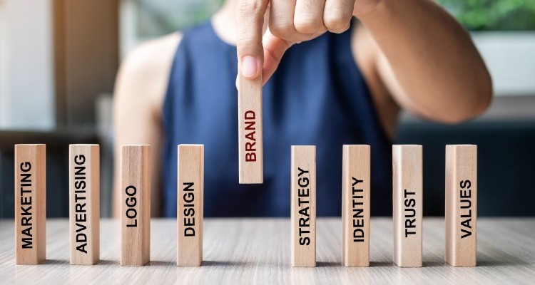 businesswoman-hand-placing-or-pulling-wooden-dominoes-with-brand-text-and-marketing-advertising-logo_t20_YwXeLX (1) (1)