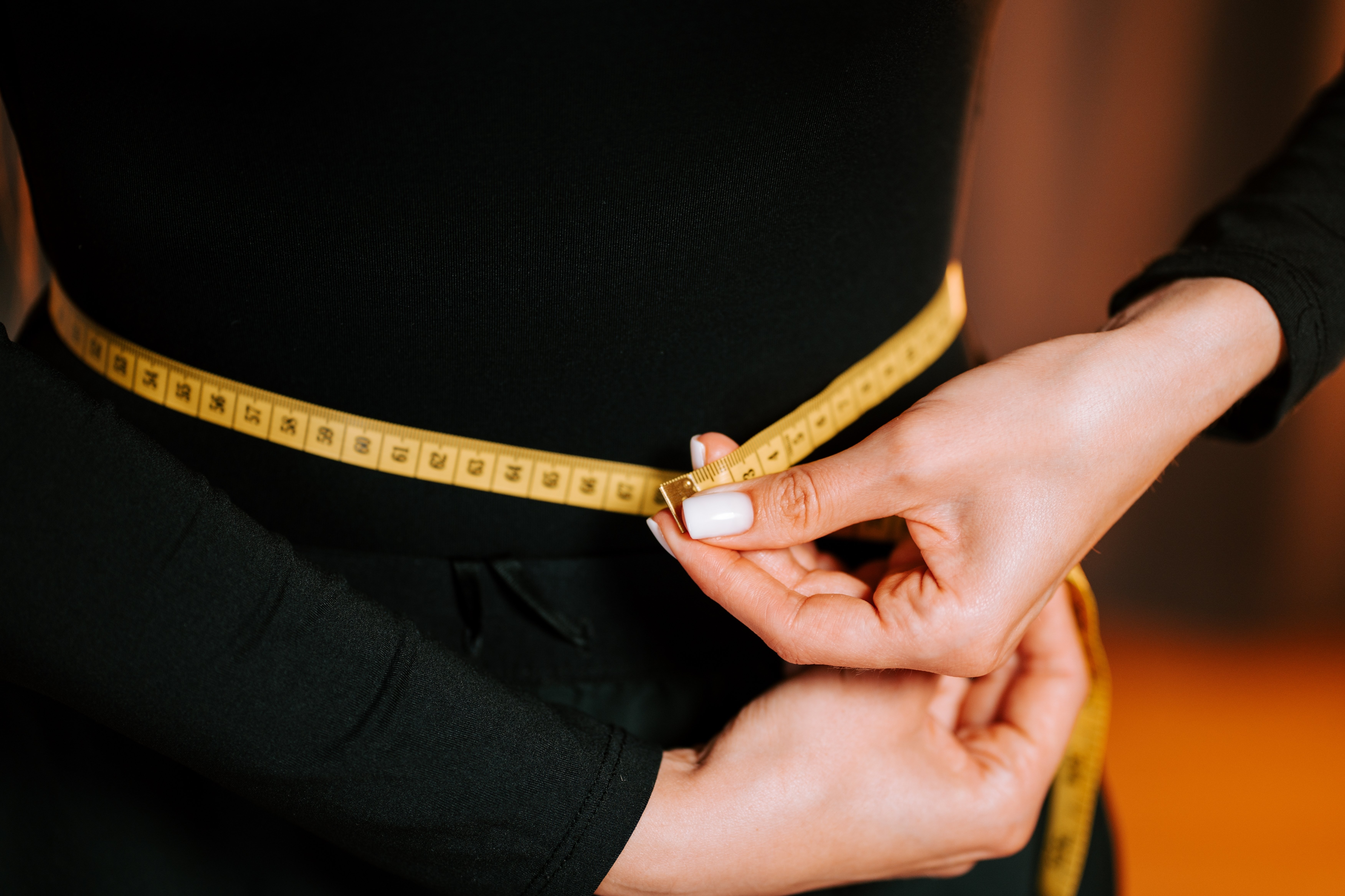 image of a woman checking the size of her waist